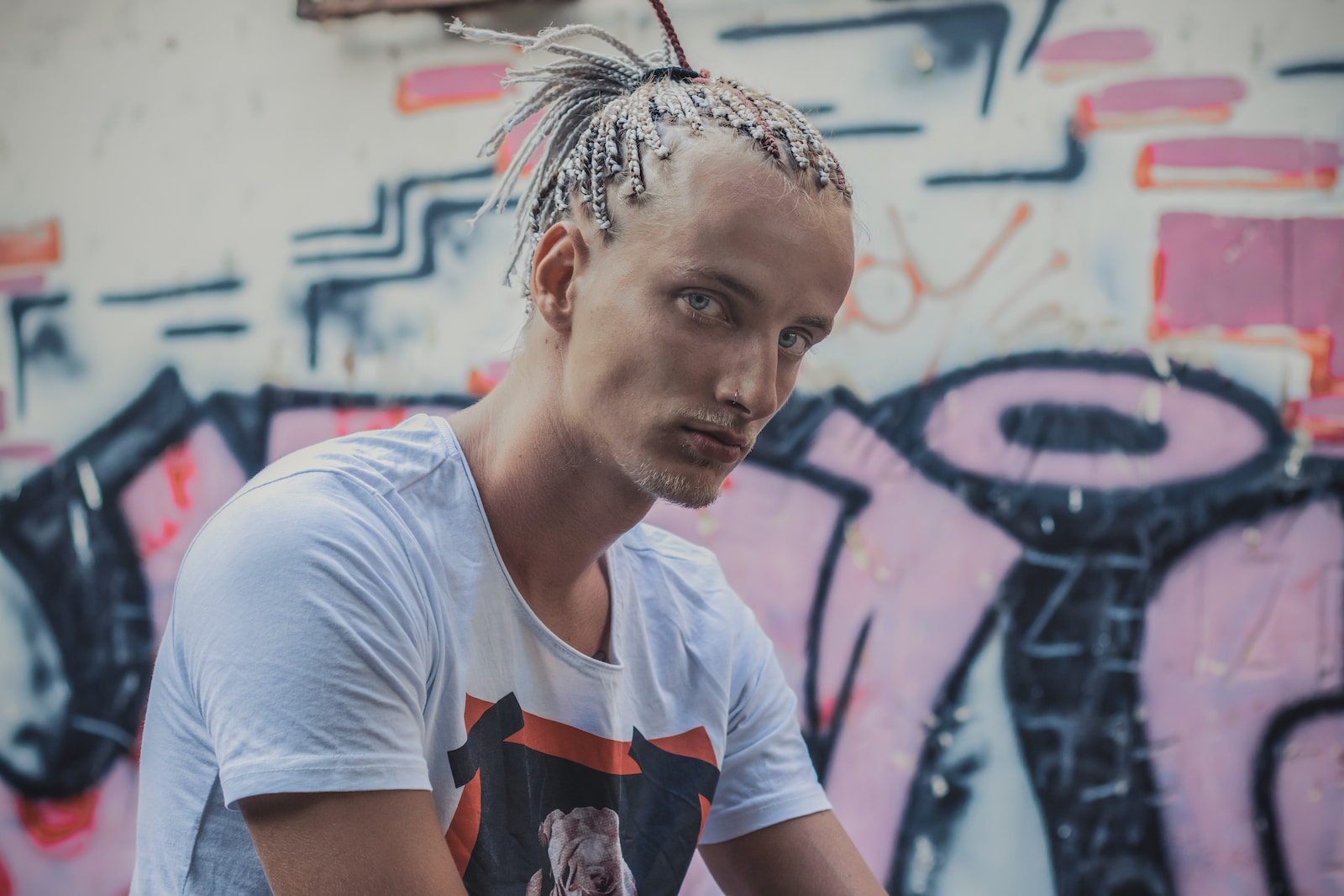 man standing beside grafitti wall during daytime