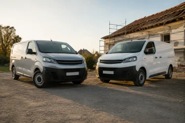 Deux fourgonnettes utilitaires garées côte à côte dans un parking de concession d'occasion